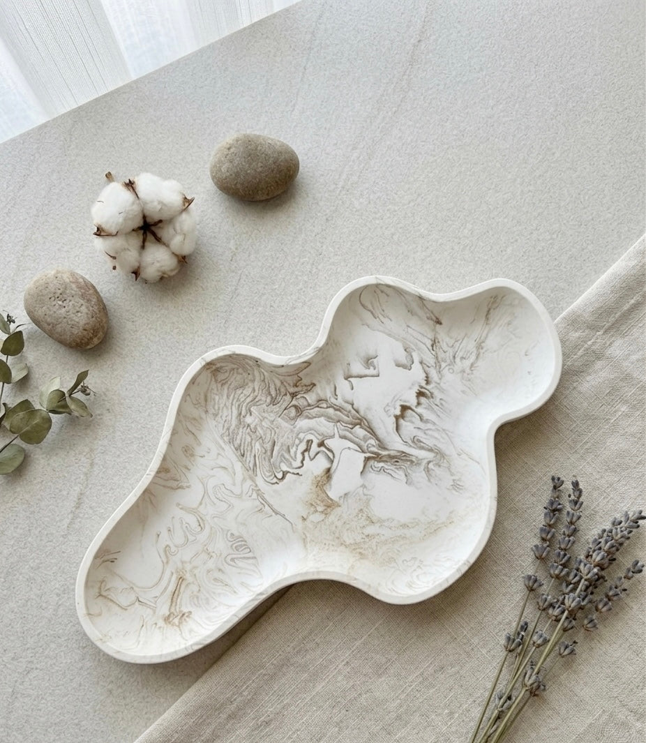 Plateau décoratif allongé en jesmonite effet marbre beige avec forme organique et finition artisanale