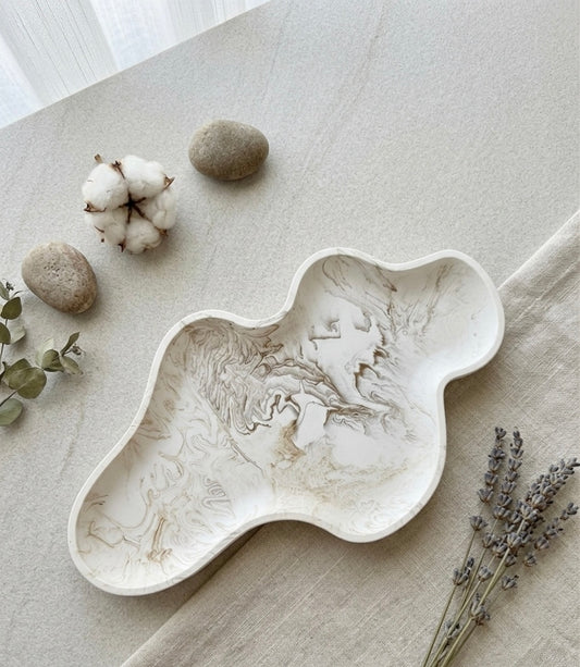Plateau décoratif allongé en jesmonite effet marbre beige avec forme organique et finition artisanale